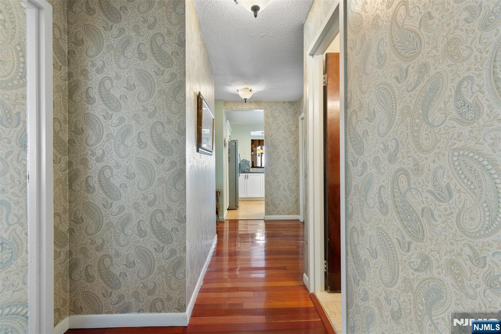 151 Prospect Avenue, Unit 9D Hackensack, NJ 07601 - Photo 22 of 38 a view of a hallway with wooden floor and a bathroom