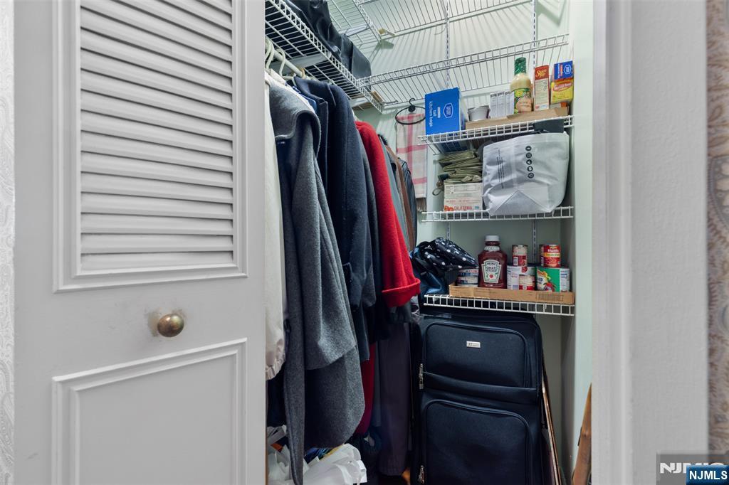 151 Prospect Avenue, Unit 9D Hackensack, NJ 07601 - Photo 23 of 38 a view of walk in closet with clothes and shoes