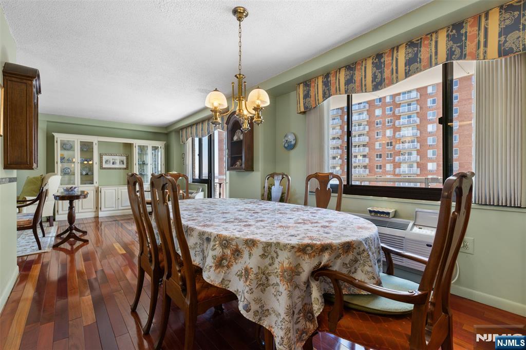 151 Prospect Avenue, Unit 9D Hackensack, NJ 07601 - Photo 8 of 38 a dining room with furniture a chandelier and wooden floor