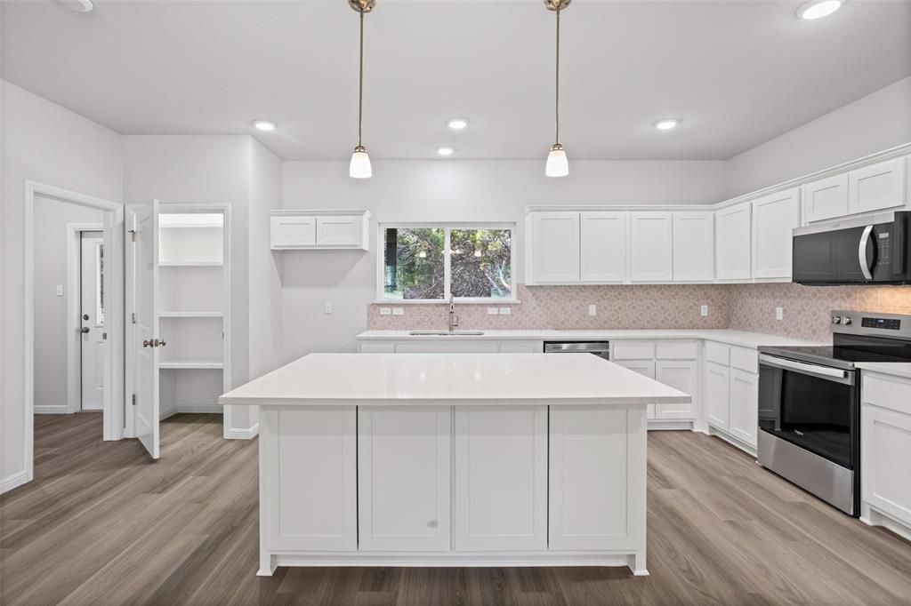 9320 Apache Trail Rio Vista, TX 76093 - Photo 17 of 33 a kitchen with kitchen island a sink stainless steel appliances and cabinets