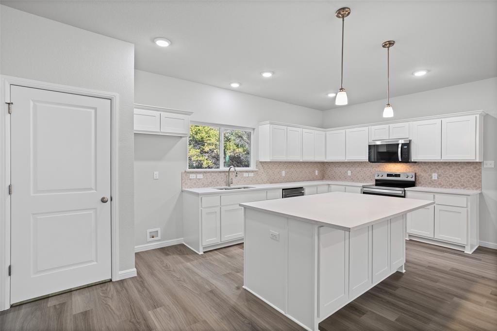 9320 Apache Trail Rio Vista, TX 76093 - Photo 21 of 33 a kitchen with kitchen island white cabinets and white appliances