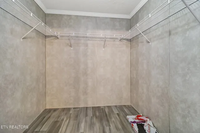 a view of walk in closet with wooden floor