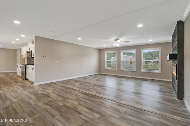 a view of empty room with wooden floor and window