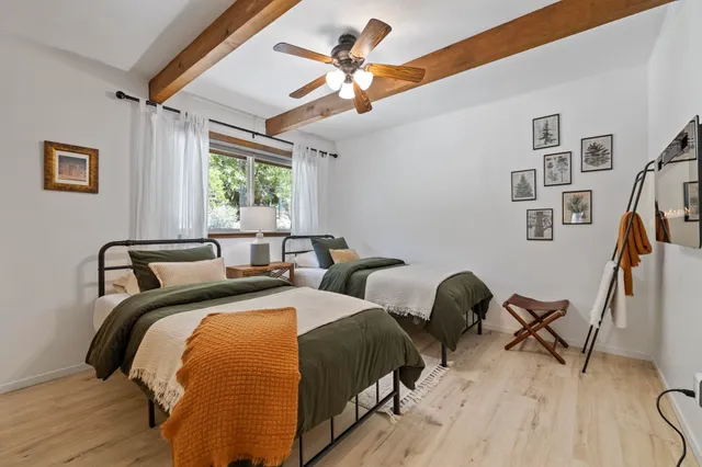 a bedroom with two beds and a large window