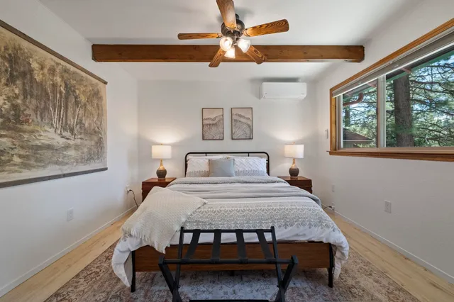 a bedroom with a bed paintings on the wall and a window