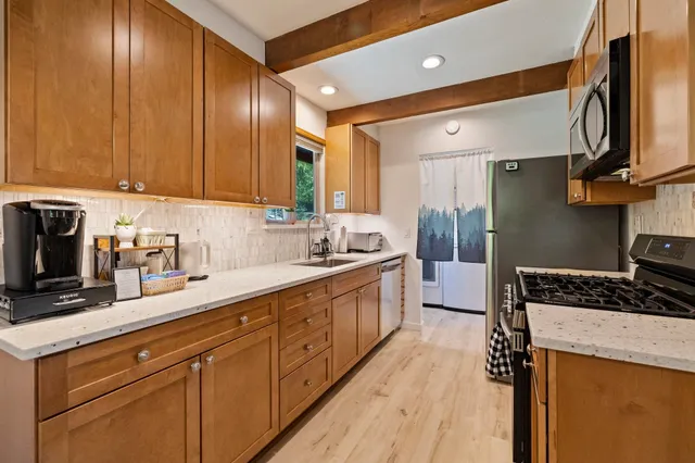 a kitchen with stainless steel appliances granite countertop a stove microwave and refrigerator