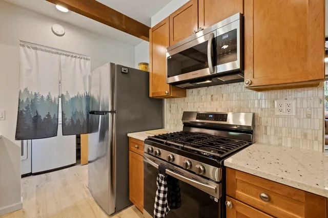 a kitchen with a sink window and chairs