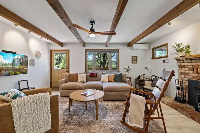 a living room with furniture a fireplace and a chandelier