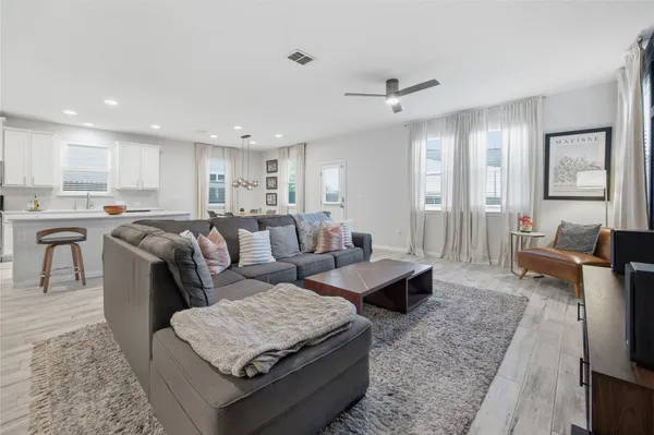 a kitchen with stainless steel appliances granite countertop a table chairs refrigerator and sink