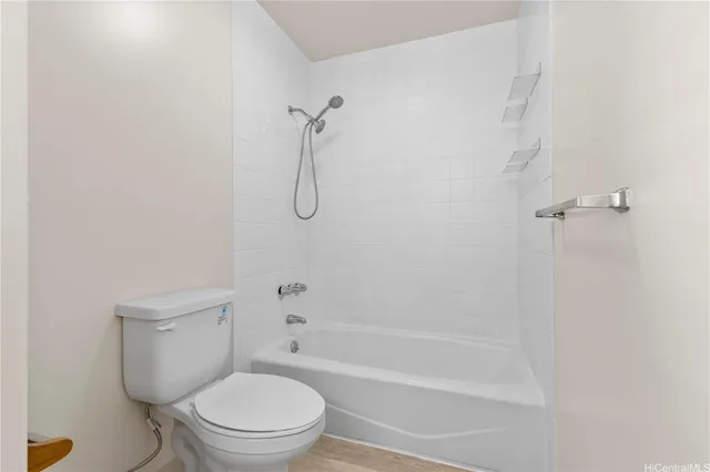 a white toilet sitting next to a bath tub