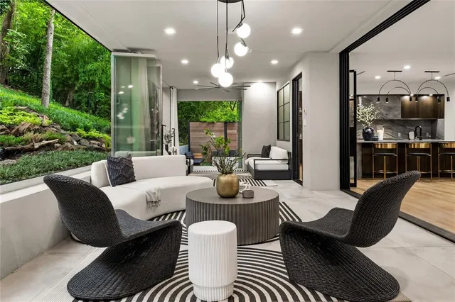 a living room with furniture a large window and a chandelier