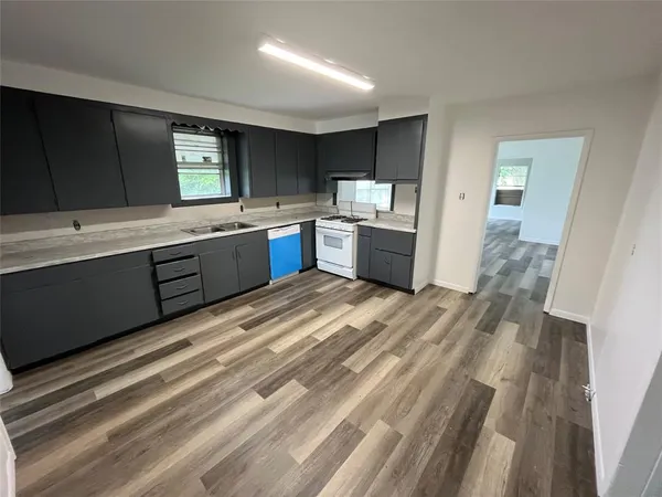 a large kitchen with kitchen island granite countertop a sink counter space and stainless steel appliances