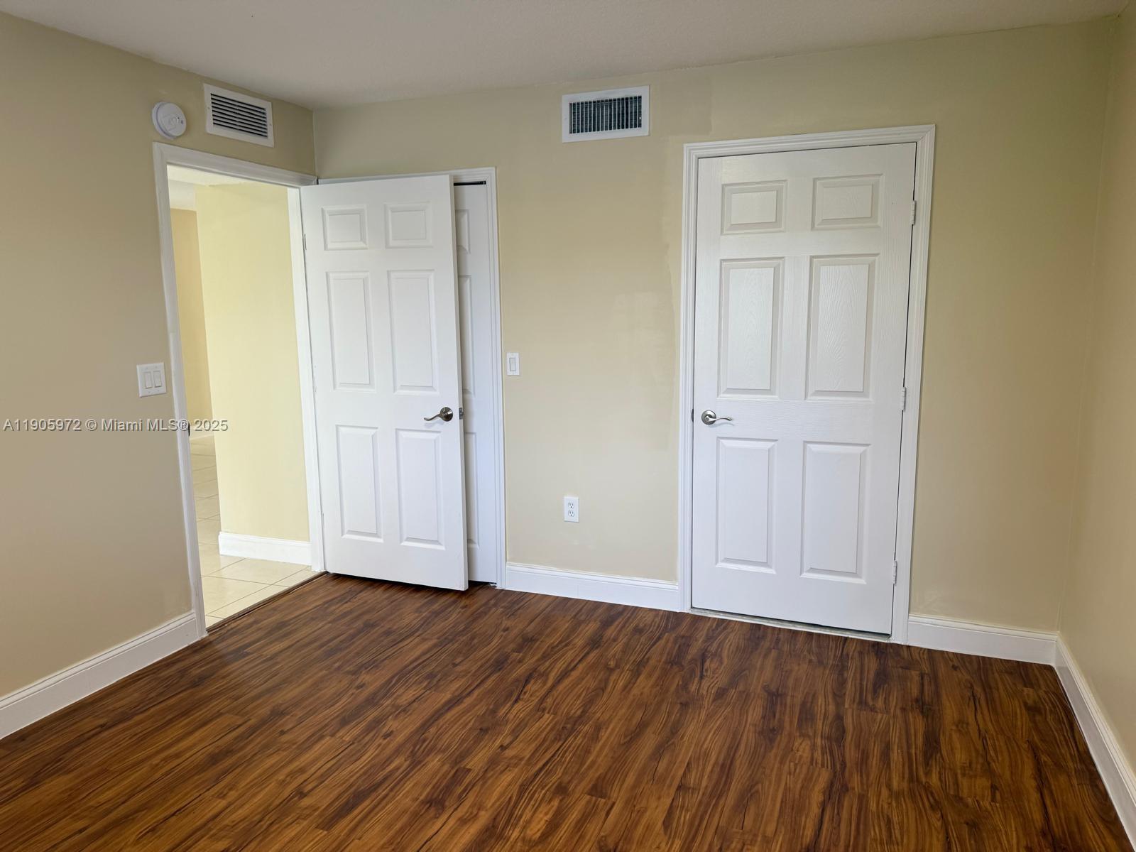 1261 Southeast 31st Court, Unit 10653 Homestead, FL 33035 - Photo 5 of 10 an empty room with wooden floor and closet area