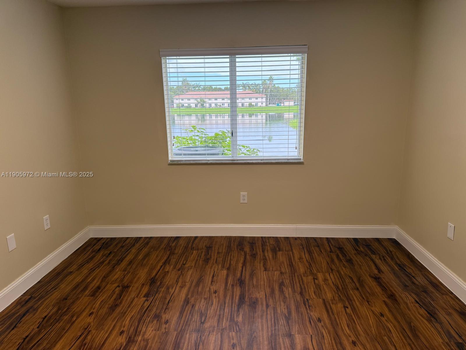 1261 Southeast 31st Court, Unit 10653 Homestead, FL 33035 - Photo 6 of 10 an empty room with wooden floor and windows