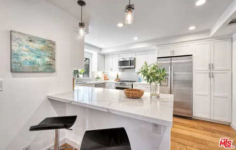 a kitchen with a refrigerator a sink and chairs