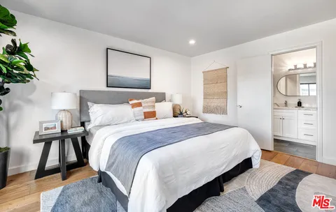 a bedroom with a bed and a painting on the wall