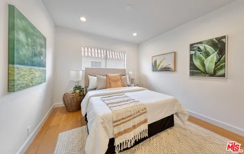 a bedroom with a bed and a painting on the wall