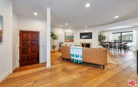 a living room with furniture and a dining table with kitchen view