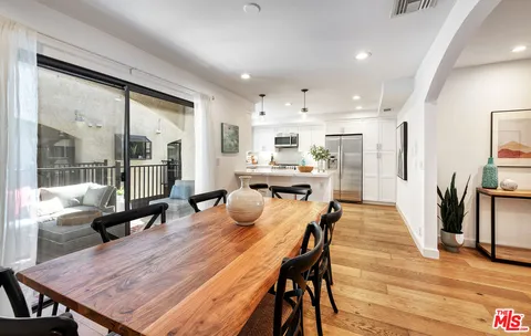 a dining room with stainless steel appliances furniture dining table and wooden floor