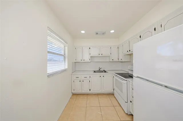 a kitchen with cabinets stainless steel appliances and a window