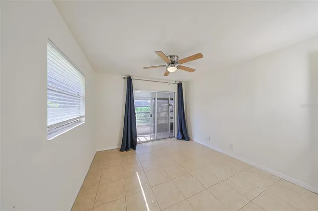 an empty room with a ceiling fan and a window
