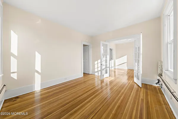 a view of empty room with wooden floor