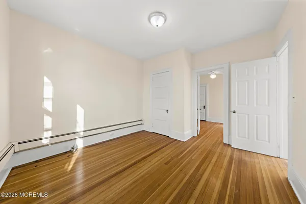 a view of empty room with wooden floor
