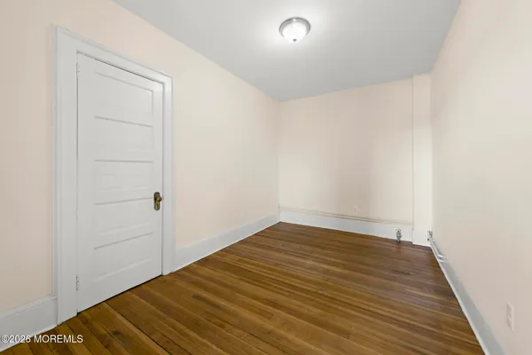 a view of empty room with wooden floor