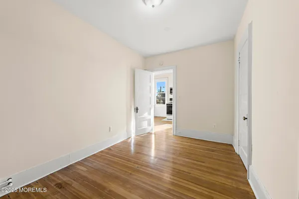 a view of empty room with wooden floor