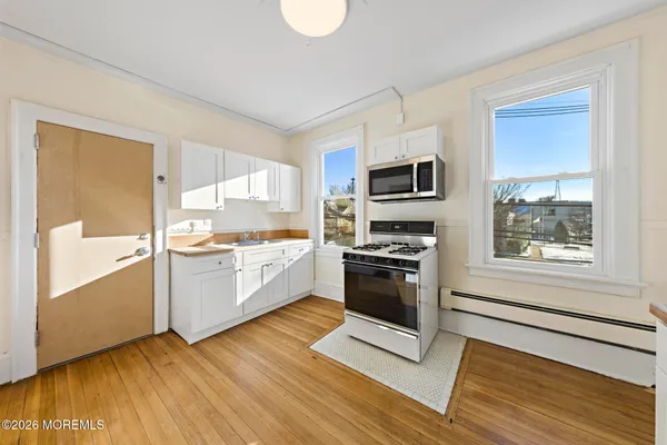 a kitchen with granite countertop a refrigerator and a stove top oven
