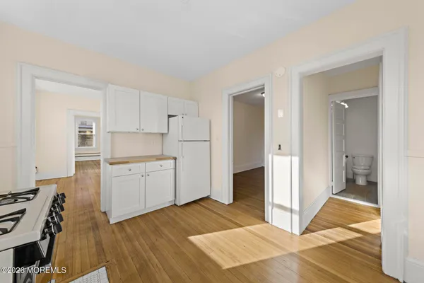 a kitchen with a refrigerator and white cabinets