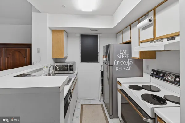 a kitchen that has a sink a stove and a refrigerator