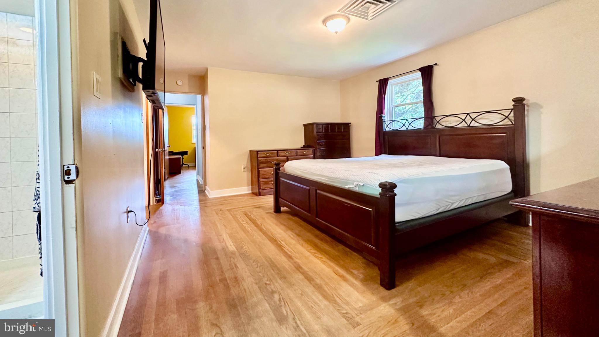 98 Maple Street Macungie, PA 18062 - Photo 22 of 56 a spacious bedroom with a bed and wooden floor
