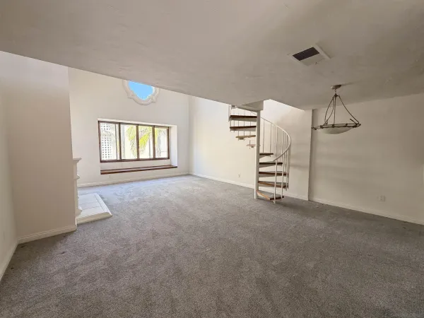 a view of staircase with white walls and door