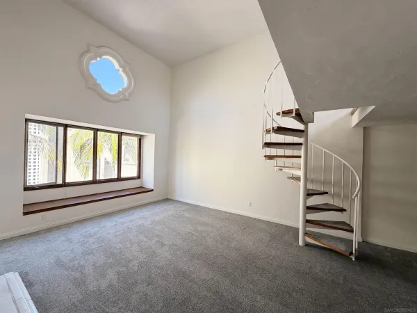 a view of an empty room with a fireplace and a window