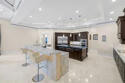 a living room with stainless steel appliances kitchen island granite countertop furniture and a flat screen tv