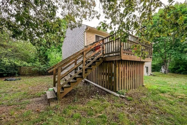 a view of a house with a yard and deck