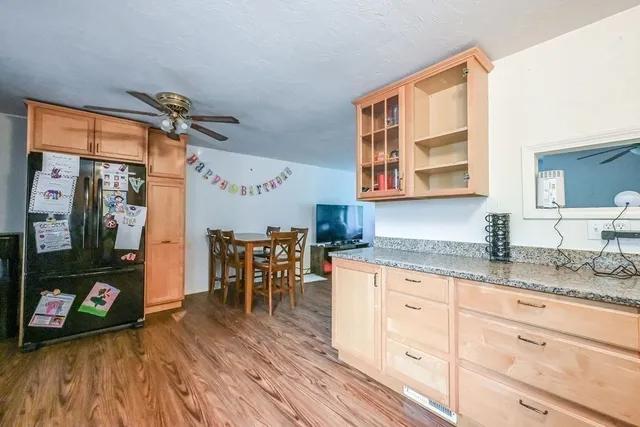 a kitchen with granite countertop a cabinets a sink a dining table and chairs