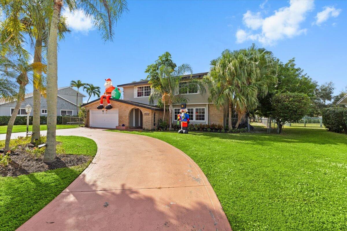 3179 Hoy Lake Road Wellington, FL 33467 - Photo 1 of 43 a front view of a house with a yard and fountain in middle