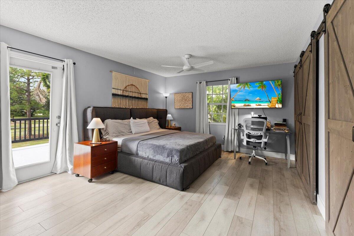3179 Hoy Lake Road Wellington, FL 33467 - Photo 18 of 43 a bedroom with a bed furniture and a flat tv screen