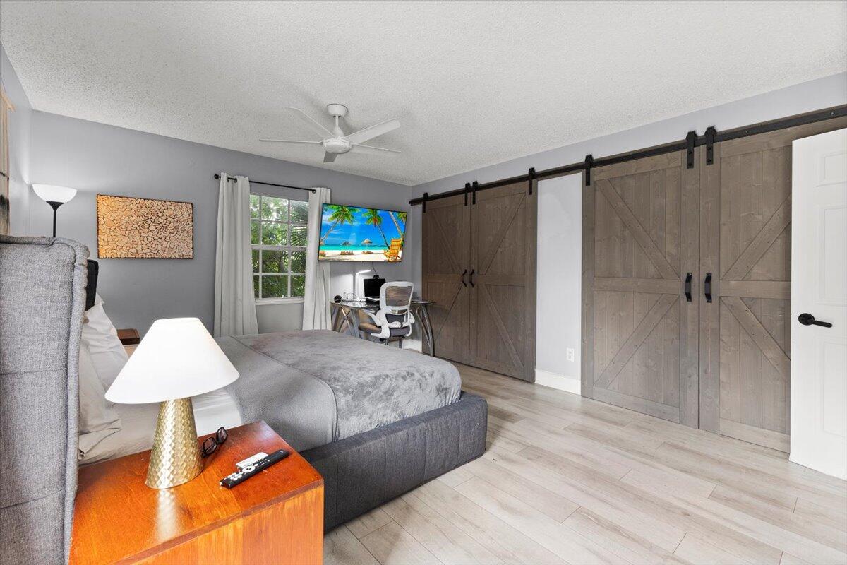 3179 Hoy Lake Road Wellington, FL 33467 - Photo 19 of 43 a spacious bedroom with a bed and a lamp
