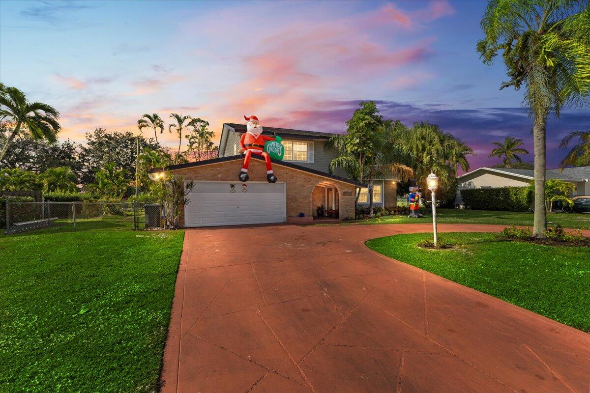 3179 Hoy Lake Road Wellington, FL 33467 - Photo 2 of 43 a front view of a house with a yard and a garage