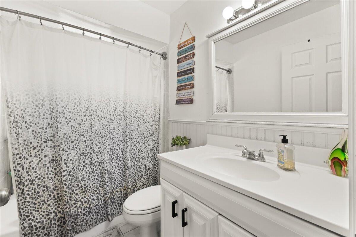 3179 Hoy Lake Road Wellington, FL 33467 - Photo 23 of 43 a bathroom with a sink a toilet and shower curtain