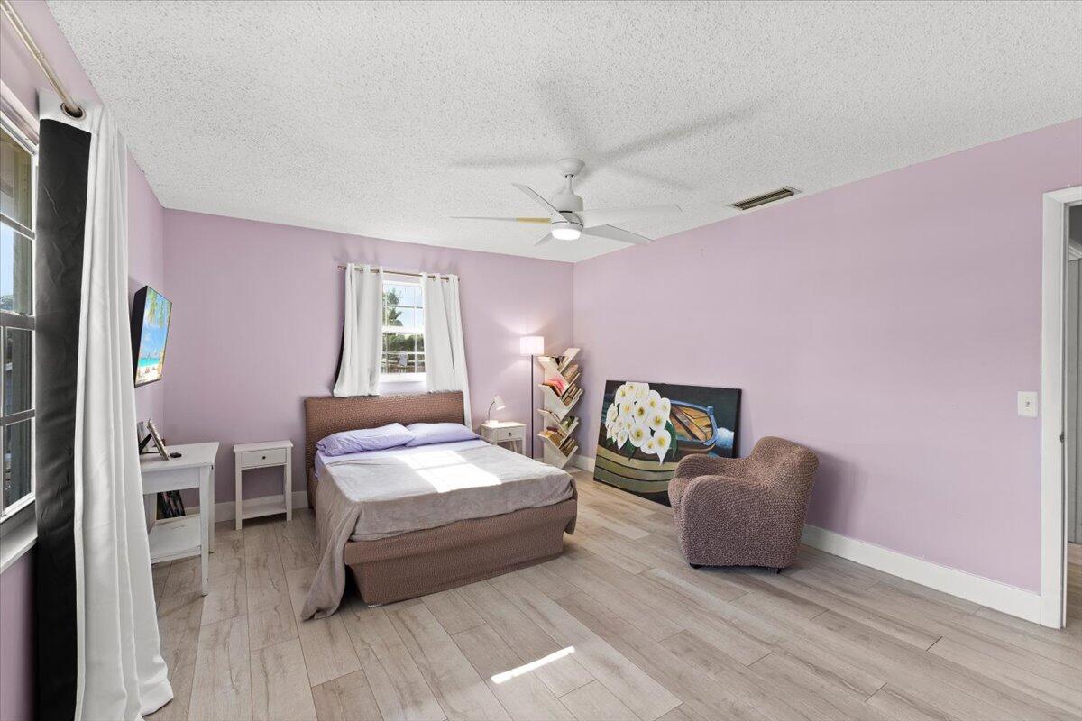 3179 Hoy Lake Road Wellington, FL 33467 - Photo 30 of 43 a spacious bedroom with a bed and a chandelier
