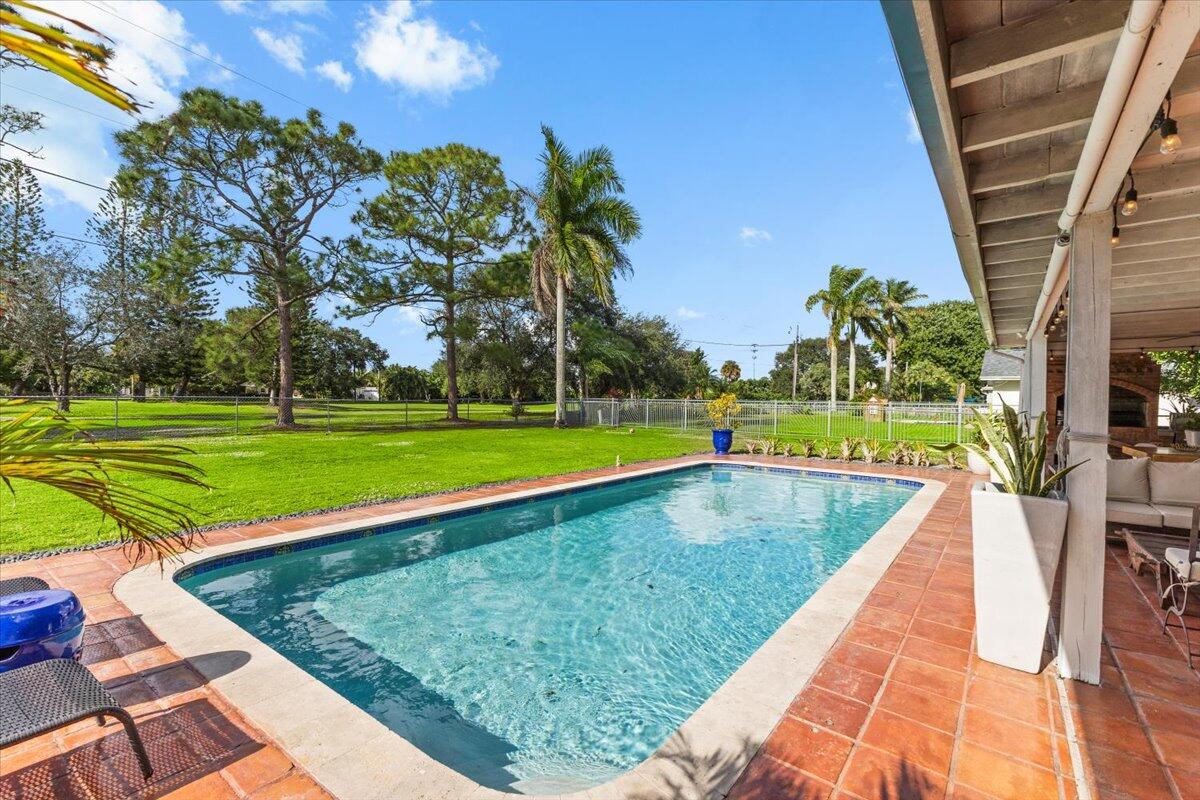 3179 Hoy Lake Road Wellington, FL 33467 - Photo 36 of 43 a view of a swimming pool with an outdoor space and seating area