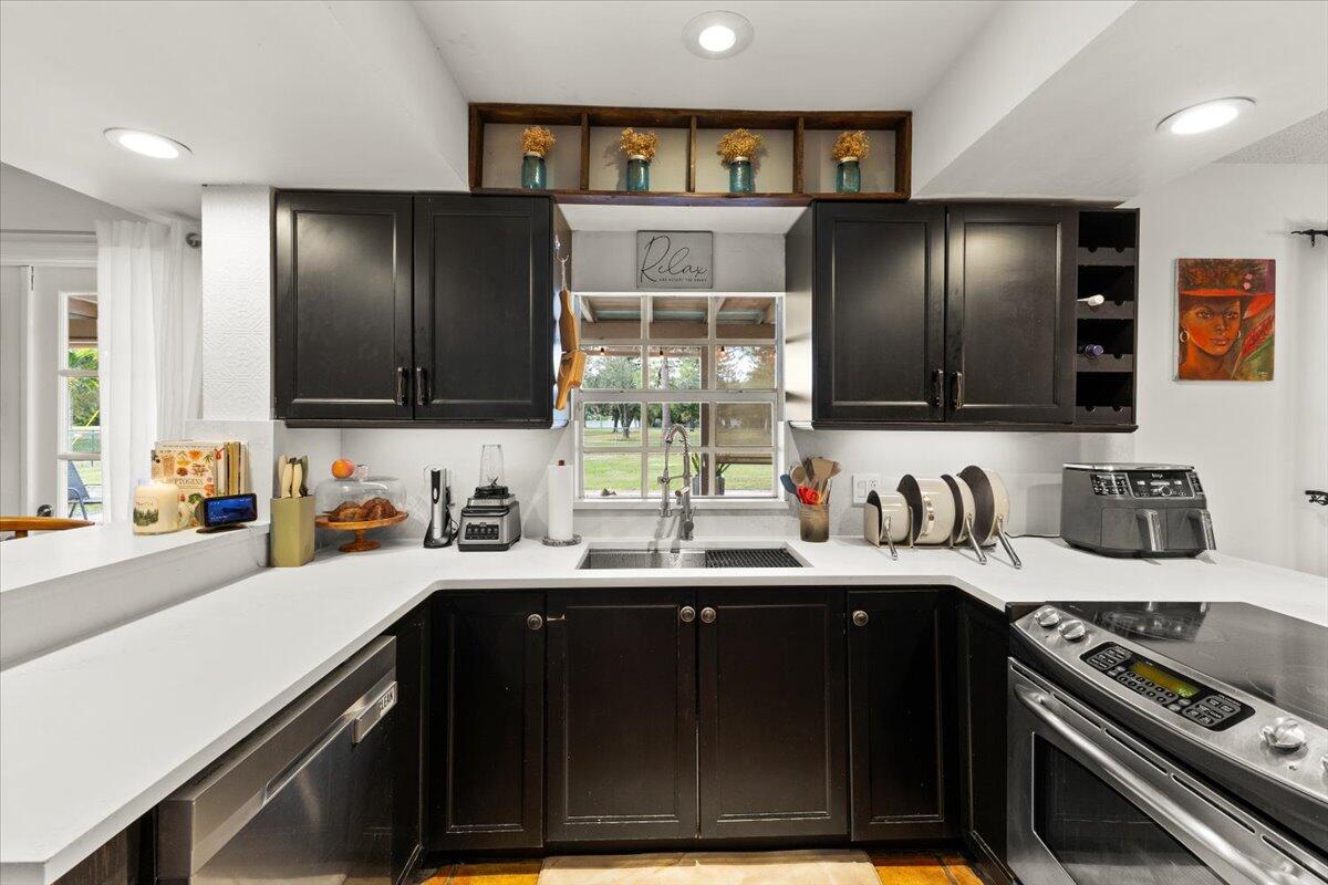 3179 Hoy Lake Road Wellington, FL 33467 - Photo 9 of 43 a kitchen with stainless steel appliances a sink stove and cabinets