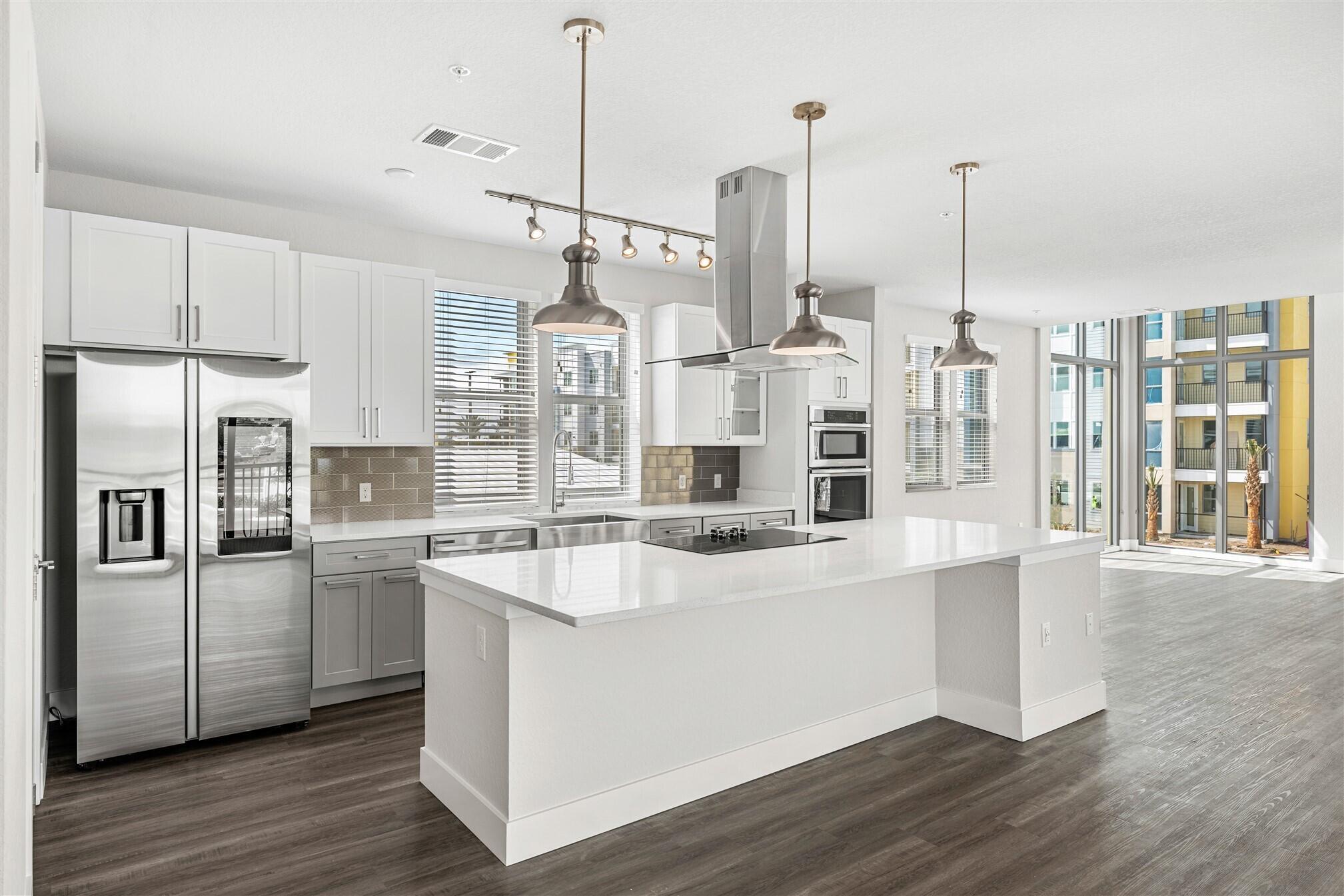8663 Ivanhoe Drive Melbourne, FL 32940 - Photo 13 of 36 a kitchen with stainless steel appliances a refrigerator a sink and wooden floor
