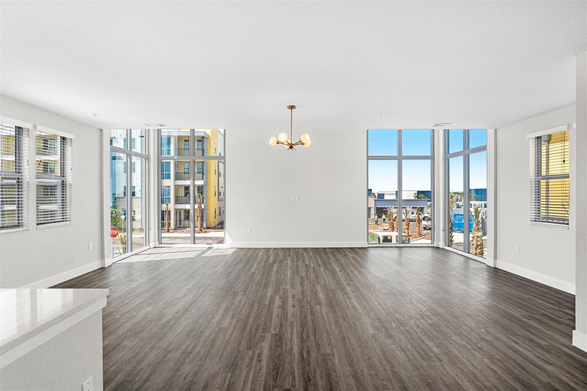 8663 Ivanhoe Drive Melbourne, FL 32940 - Photo 19 of 36 wooden floor in an empty room with a window