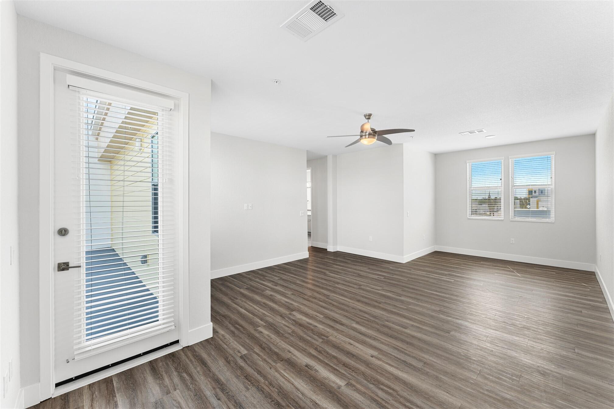 8663 Ivanhoe Drive Melbourne, FL 32940 - Photo 34 of 36 an empty room with wooden floor cabinet and windows