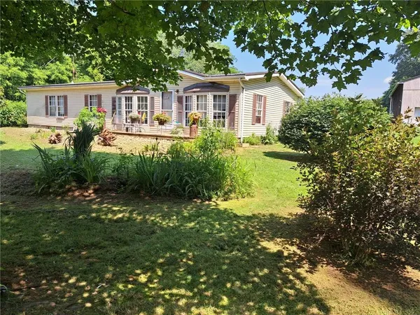 a front view of a house with a yard and lake view